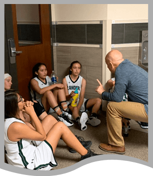 Coach talking to girls basketball players